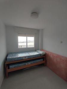 San BlasにあるLa Manga Estacioのベッドと窓が備わる小さな客室です。