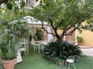 un tavolo e sedie sotto un ombrellone in giardino di Le Dimax a Sant'Agnello