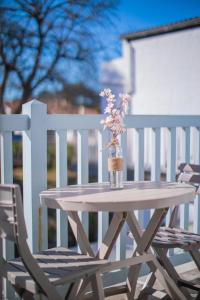 a wooden table with a vase of flowers on it at Hôtel Land'Azur in Mimizan-Plage