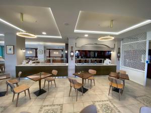 a restaurant with tables and chairs and a counter at Hotel Platon Beach in Olympic Beach