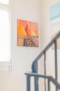a painting hanging on a wall next to a staircase at Hôtel Land'Azur in Mimizan-Plage