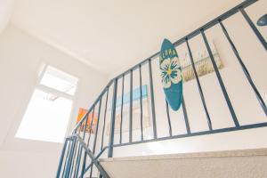 a surfboard hanging on the railing of a staircase at Hôtel Land'Azur in Mimizan-Plage