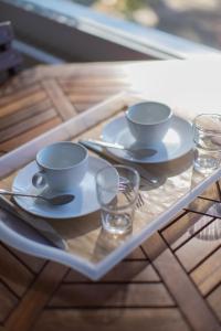 two cups and saucers on a tray on a table at Hôtel Land'Azur in Mimizan-Plage