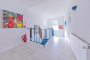 a hallway with a staircase with paintings on the walls at Hôtel Land'Azur in Mimizan-Plage