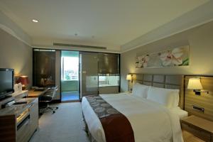 台北的住宿－福容大飯店台北一館，一间卧室配有一张床、一张书桌和一台电视
