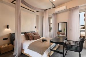 a bedroom with a bed and a table and a desk at Anaem Eclectic Rooms in Chania