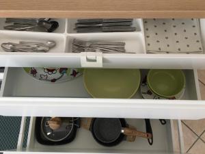 un cassetto pieno di piatti e utensili di Appartamento ZenaUp a Saronno