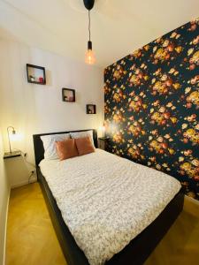 1 dormitorio con 1 cama con pared de flores en La Roseraie, en Rouen
