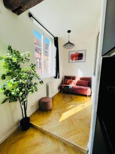 sala de estar con sofá rojo y árbol en La Roseraie, en Rouen