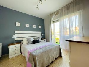 sypialnia z łóżkiem i dużym oknem w obiekcie Casa Aurea w mieście O Grove
