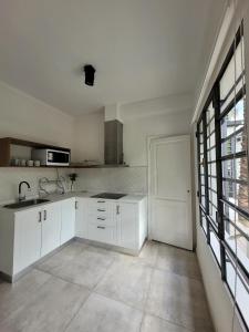 a kitchen with white cabinets and a large window at Casa Villanueva in Mendoza