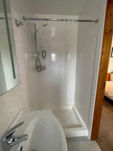 a bathroom with a shower with a toilet and a sink at Royal Oak Guesthouse in Orkney