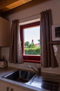 uma cozinha com um lavatório e uma janela em Tvoja Chata em Banská Štiavnica