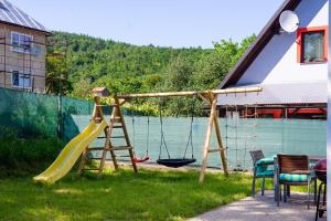 um parque infantil com escorrega e um baloiço em Tvoja Chata em Banská Štiavnica