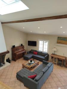 a living room with a couch and a piano at Domaine des Prés de Joussac - Protocole sanitaire strict in Jau-Dignac-et-Loirac