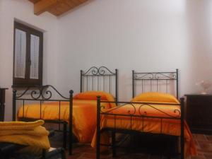 2 camas con sábanas de color naranja en una habitación en Il Poggio del Sole, en Montefalco