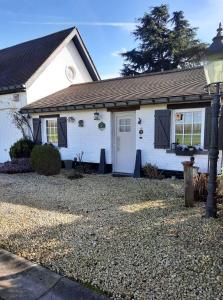 uma casa branca com uma luz de rua em frente em Gîte le Quesnoy em Martimont