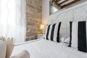 1 dormitorio con cama blanca y almohadas blancas y negras en Premium Apartment, en Dubrovnik