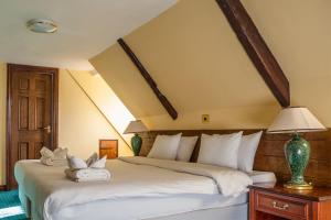 ein Schlafzimmer mit einem großen Bett mit weißen Kissen in der Unterkunft The Kings Head Inn in Llandovery