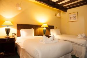 Habitación de hotel con 2 camas y toallas. en The Kings Head Inn en Llandovery