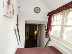 a hallway with a window and a red rug at The Castle Inn Hotel Bramber in Steyning +28 photos