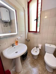 ein Badezimmer mit einem weißen Waschbecken und einem WC in der Unterkunft Arteg Apartments - Comfort in Durrës