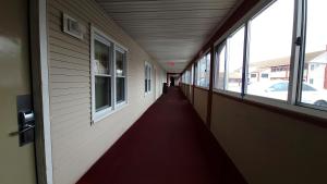 un pasillo vacío de un edificio con ventanas en Red Carpet Inn West Springfield en West Springfield