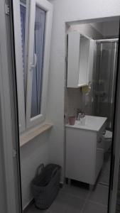 a bathroom with a sink and a toilet and a window at EMA HOUSE in Zadar