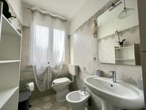 a bathroom with a sink and a toilet and a mirror at House Viareggio in Viareggio +41 photos