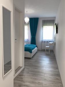 a bedroom with a bed and blue curtains and a mirror at Gizell Apartment 1 in Sibiu