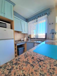 une cuisine avec des placards bleus et un comptoir dans l'établissement Precioso apartamento con ascensor a 80 metros del mar, à Torrevieja