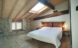 a bedroom with a large bed and a skylight at Casa rural Abatetxe in Elgóibar +23 photos