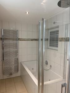 a white bathroom with a tub and a shower at Ferienwohnung Allersberg in Allersberg