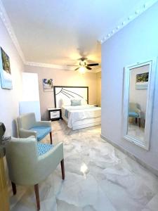 a bedroom with a bed and a chair and a mirror at Hotel Sand Bay in Punta Rucia +35 photos