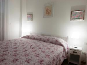 een slaapkamer met een bed met een roze dekbed bij La Vie En Rose in Rapallo