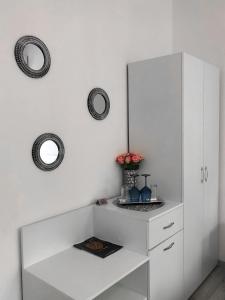 a white cabinet with a mirror and flowers on it at Gizell Apartment 1 in Sibiu