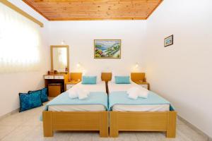 two beds in a room with white walls at Venus Island Studios in Líndos