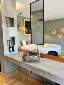 a bathroom with a sink and a bedroom with a bed at Monte Gois Country House e Spa in Curvatos