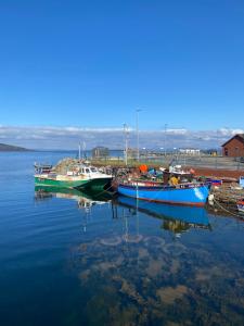 three boats are docked in a body of water at Wee Silverburn in Whiting Bay