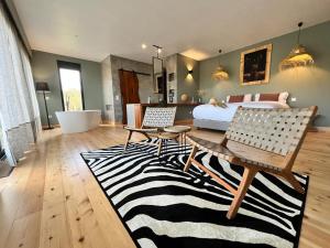 a living room with a bed and a zebra rug at Monte Gois Country House e Spa in Curvatos