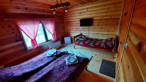 1 dormitorio con 2 camas en una cabaña de madera en Log cabin 1 Merdovic, en Mojkovac