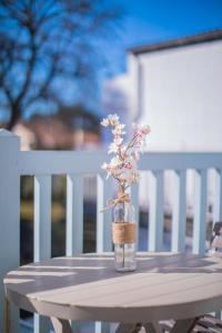 a vase with flowers in it sitting on a table at Hôtel Land'Azur in Mimizan-Plage