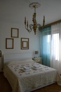 a bedroom with a bed and a chandelier at Vintage House in Pisa