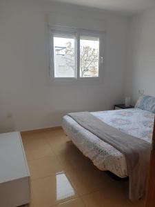 a white room with a bed and two windows at Condado de Alhama N5 in Alhama de Murcia