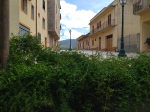 una calle con edificios y arbustos en una ciudad en mamarita, en Sambuca di Sicilia