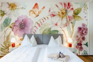 ein Schlafzimmer mit einem Bett mit Blumen an der Wand in der Unterkunft Das Franzl - Bett & Brot in St. Wolfgang