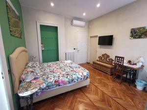 a bedroom with a bed and a table and a television at B&B Ad Quintum Torino in Collegno