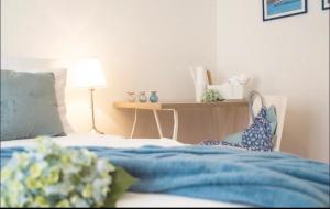斯普利特的住宿－拉娜旅館，一间卧室配有一张带蓝色床单的床和一张桌子。