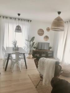 ein Wohnzimmer mit einem Tisch, Stühlen und einem TV in der Unterkunft Precioso apartamento en Monzón con terraza,piscina,parque infantil y parking in Monzón