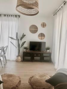 ein Wohnzimmer mit einem Flachbild-TV und weißen Wänden in der Unterkunft Precioso apartamento en Monzón con terraza,piscina,parque infantil y parking in Monzón
